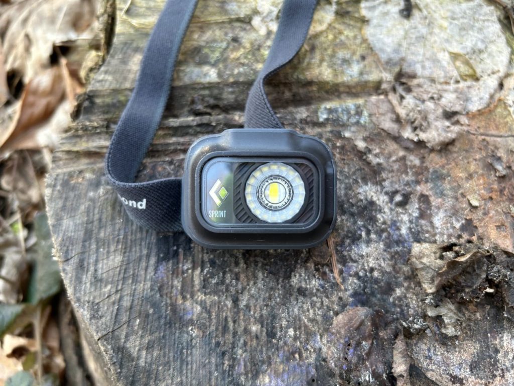 Black Diamond Sprint 225 Stirnlampe auf einem Baumstumpf im Wald