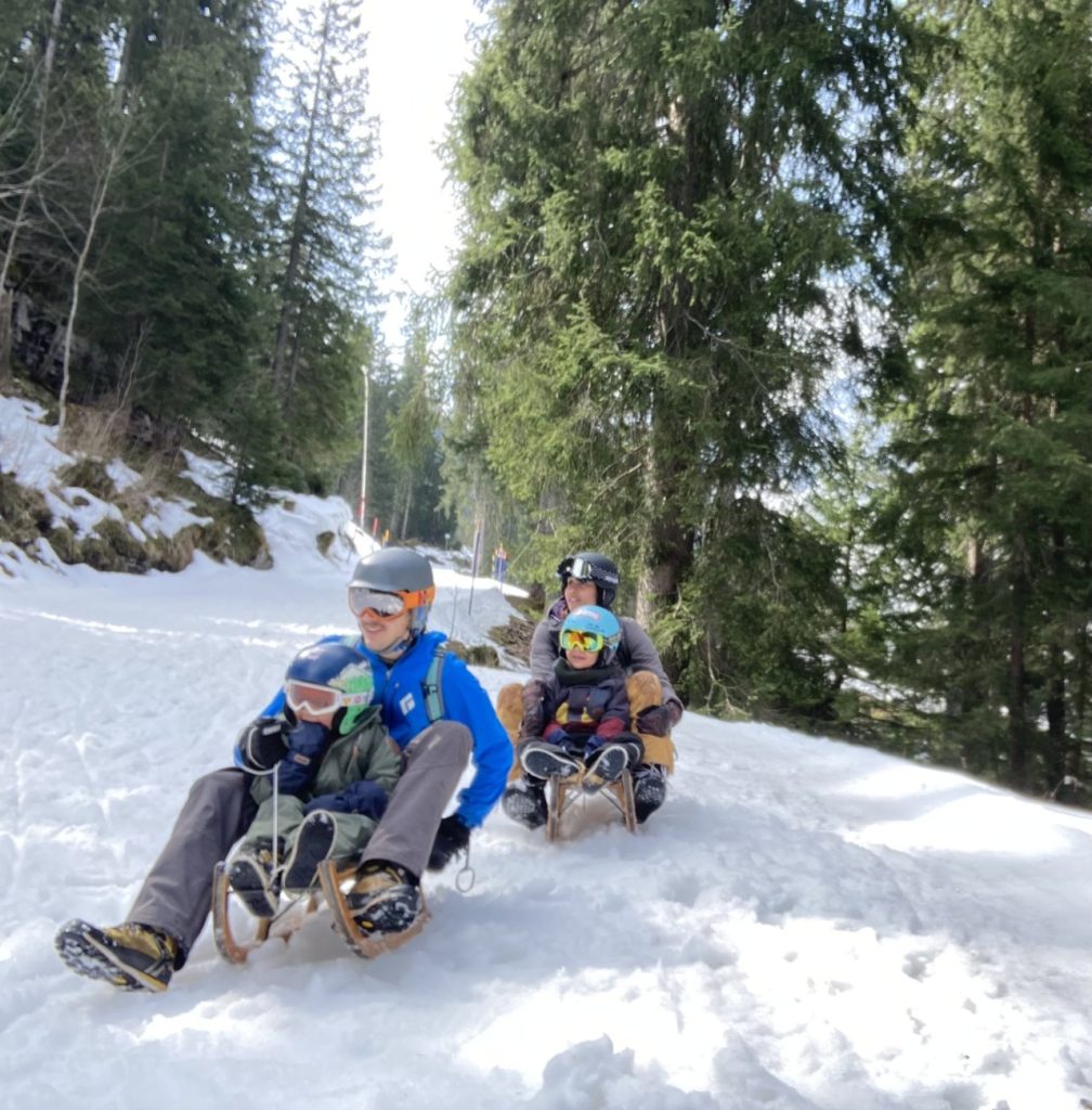 Familie beim Schlitteln im Schweizer Winter