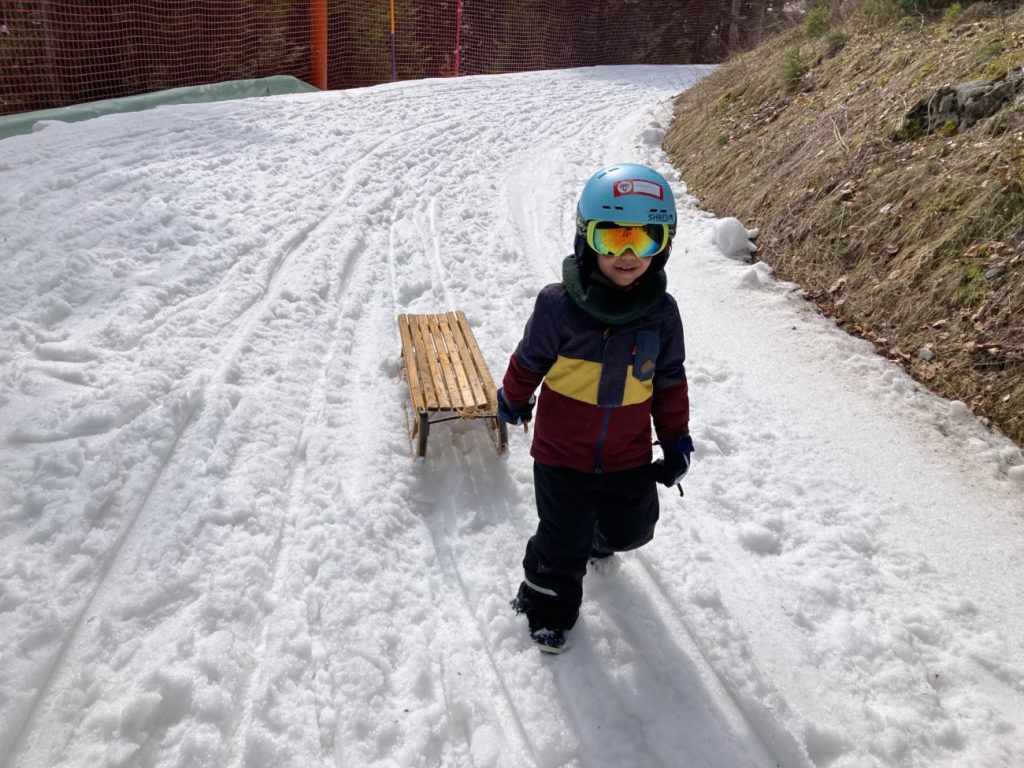 Kind beim Schlitteln im Schweizer Winter