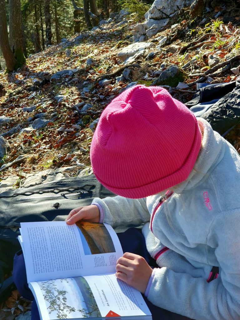 Kind blättert während einer Wanderung im Die schönsten Wanderungen im Jura Buch