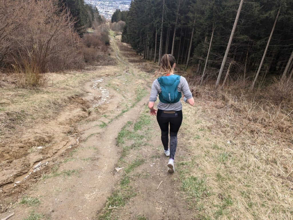 Trail Runnerin rennt bergab mit einem Paar Merrell Trail Glove 7