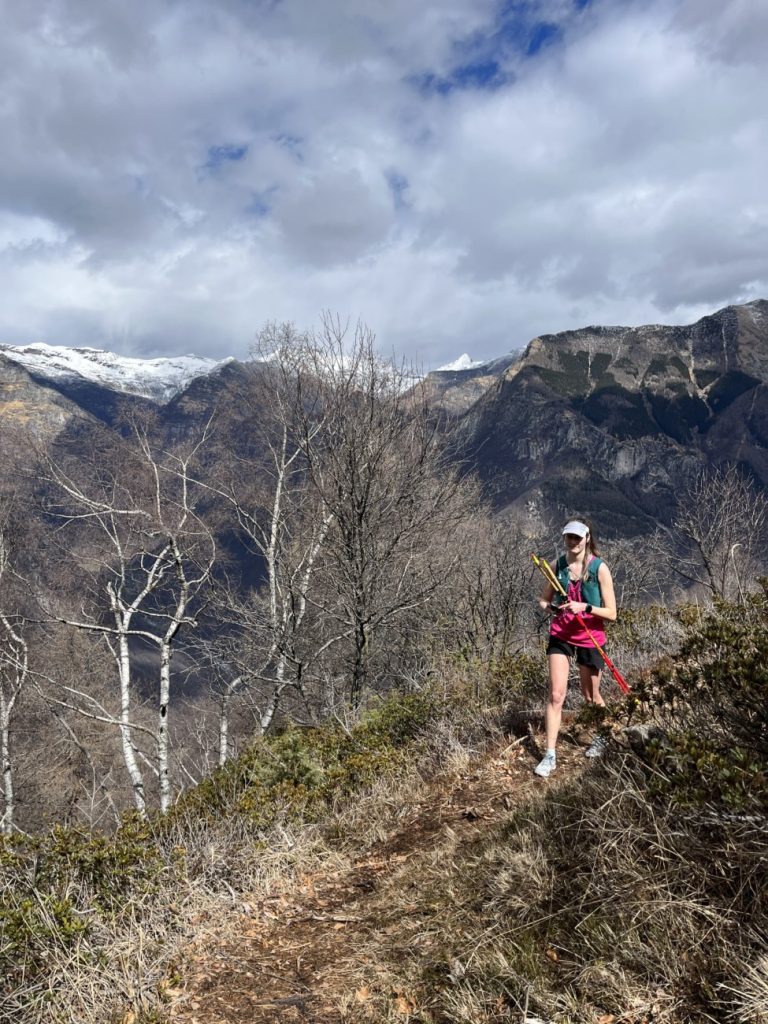Läuferin mit Stöcken auf einem Trail mit Merrell Trail Glove 7
