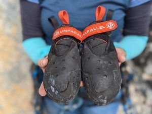 Unparallel Souped Up Kletterschuh in den Händen einer Kletterin