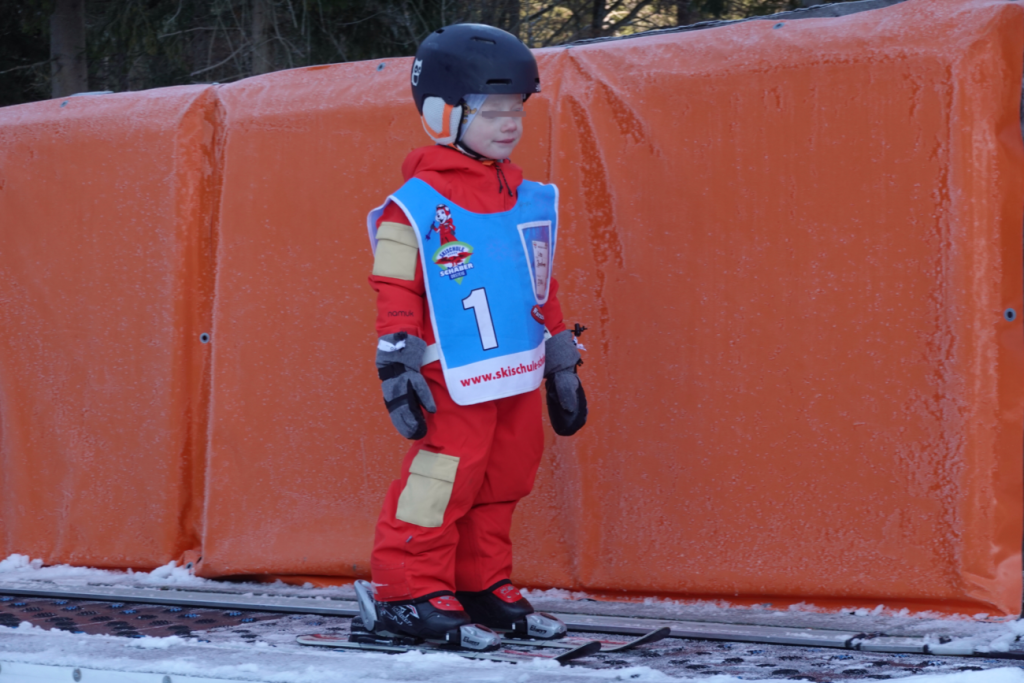 Kind im namuk Quest Skianzug lernt Skifahren