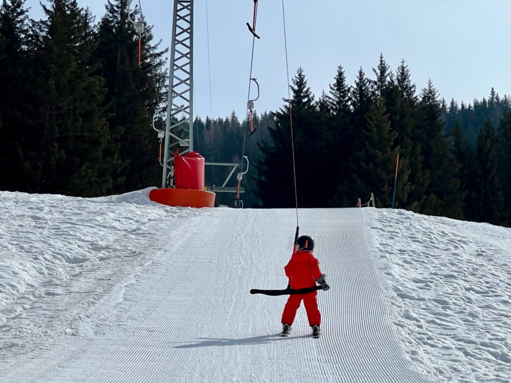 Kind im namuk Quest Skianzug beim ersten Mal mit dem Bügellift fahren