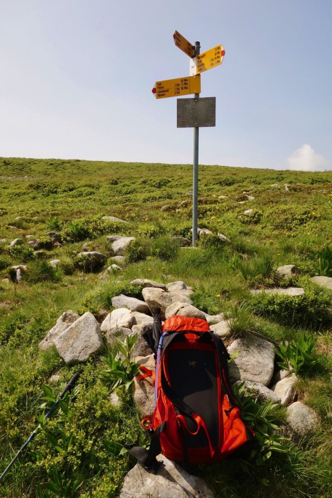 Bergwandern Sicherheitstipps: Weiss-rot-weisser Wanderwegweiser in der Schweizer Natur
