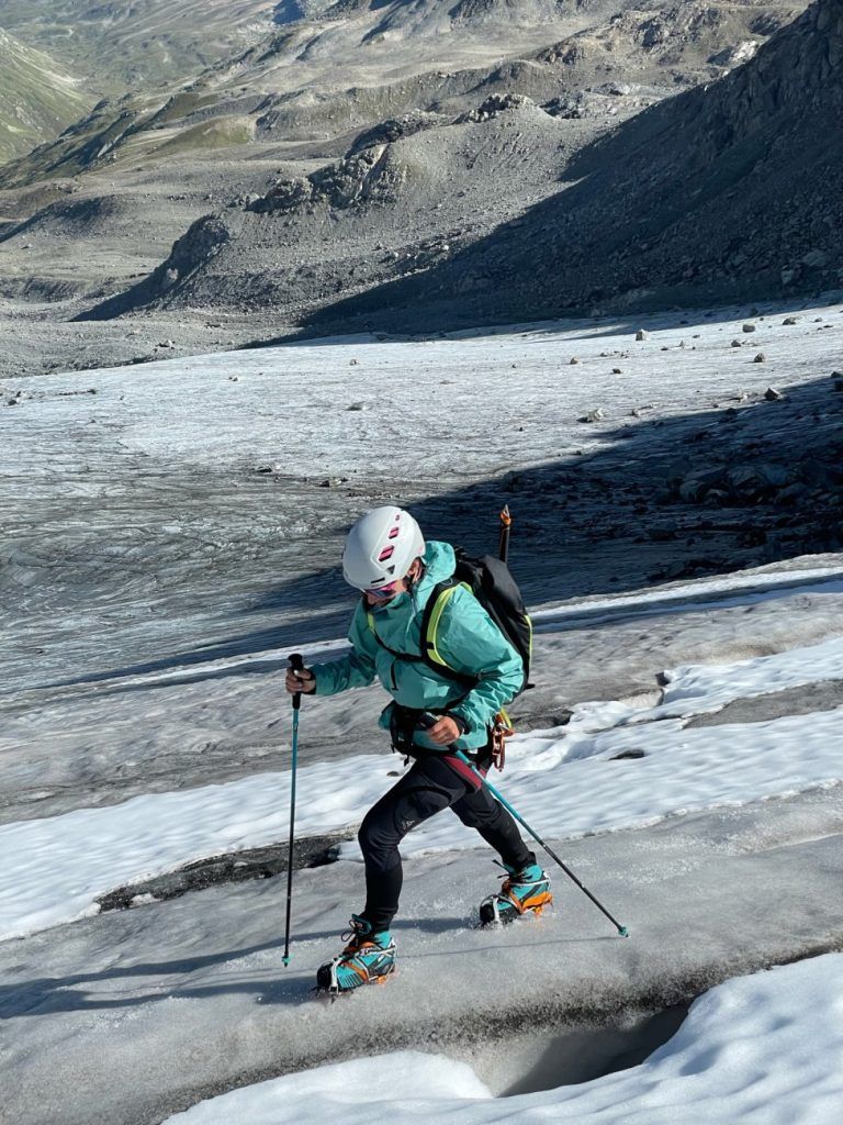 Bergsteigerin mit Patagonia Storm Racer Jacket auf einem Gletscher mit Steigeisen