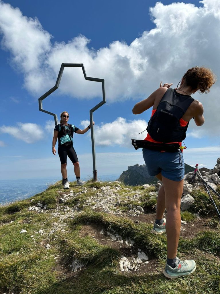Trailrunnerin mit Montane Gecko VP 12+ Rucksack beim Gipfelfoto