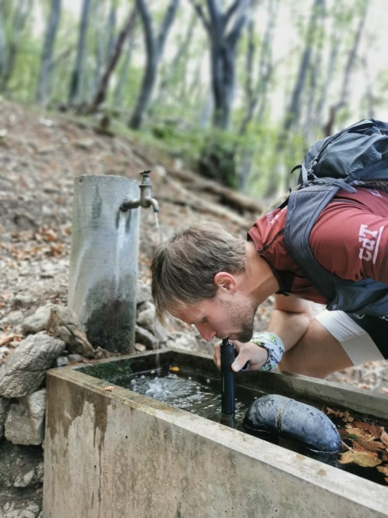 Der LifeStraw Peak Series Straw im Einsatz beim Trinken aus einem Brunnen