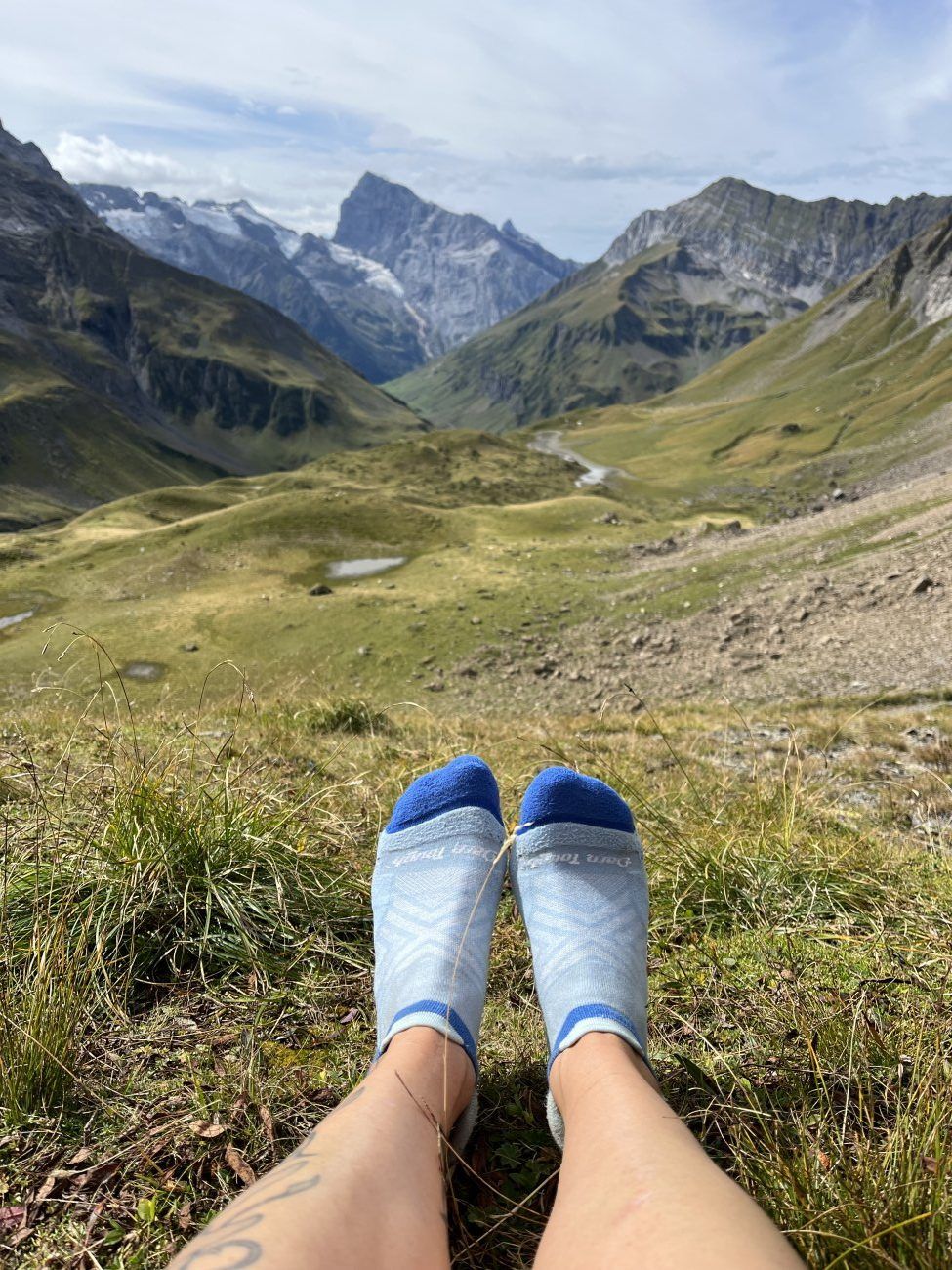 Darn Tough Women's Run No Show Tab Ultra-Lightweight Running Sock einer Trailrunnerin in den Bergen mit Panoramasicht