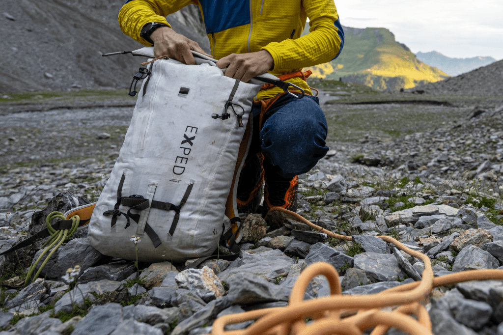Bergsteiger öffnet den Rolltop-Verschluss des Whiteout Rucksacks