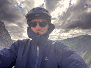 7Mesh Skypilot Jacket auf einem Bergpfad, idealer Schutz vor Wind und Wetter.