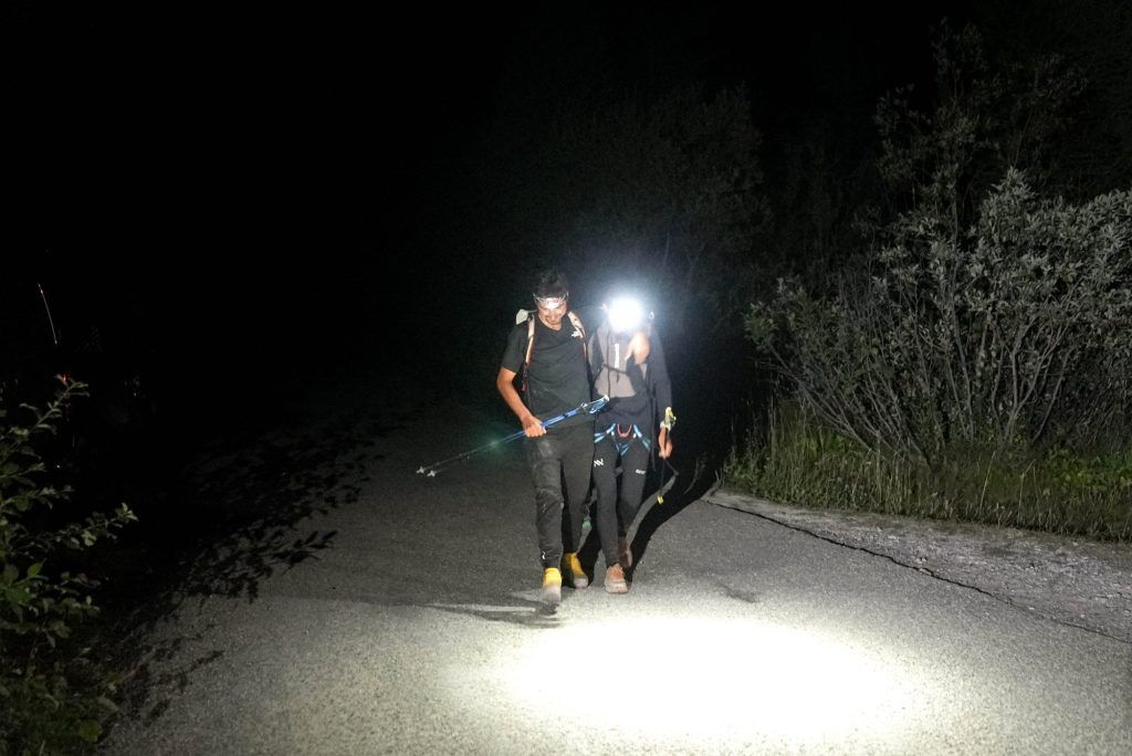 Kilian Jornet und ein Begleiter wandern in der Dunkelheit mit Stirnlampen bei Kilian Jornet Alpine Connections.