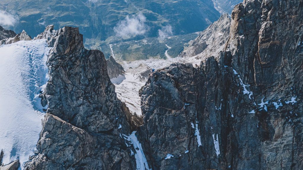 Luftaufnahme von Kilian Jornet auf einem schmalen Felsgrat in den Alpen bei Kilian Jornet Alpine Connections.