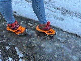 Trailrunnerin mit Nortec TRAIL 2.1 Schuhkrallen auf Boden mit Eis und Schnee