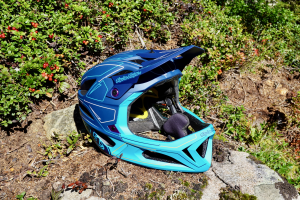 Troy Lee Designs Stage MIPS Helm in der Natur abgelegt auf einem Stein.