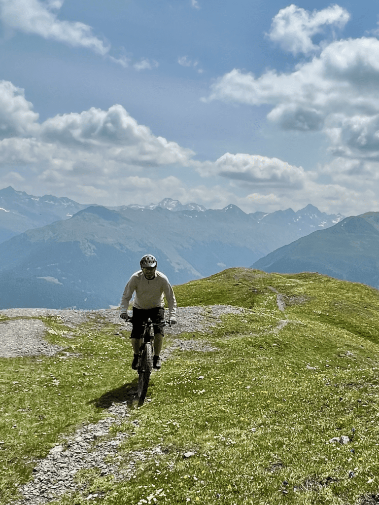 Mountainbiker in den Alpen mit react optray Sonnenbrille vor Bergpanorama