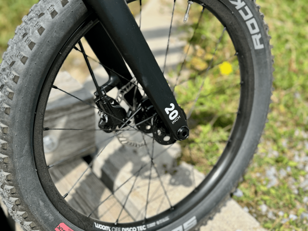 Nahaufnahme des Vorderrads mit Schwalbe-Reifen am woom OFF 4, betont die Geländetauglichkeit.