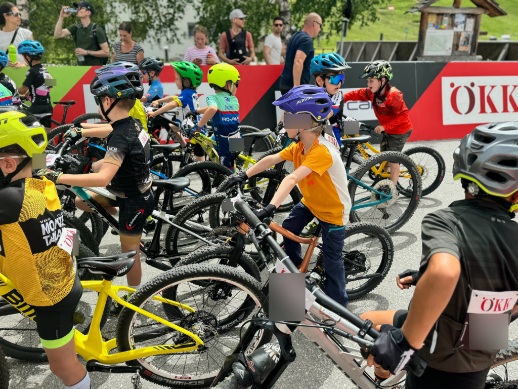 Mehrere Kinder, darunter eines mit dem woom OFF 4, bereiten sich auf ein Fahrradrennen vor.