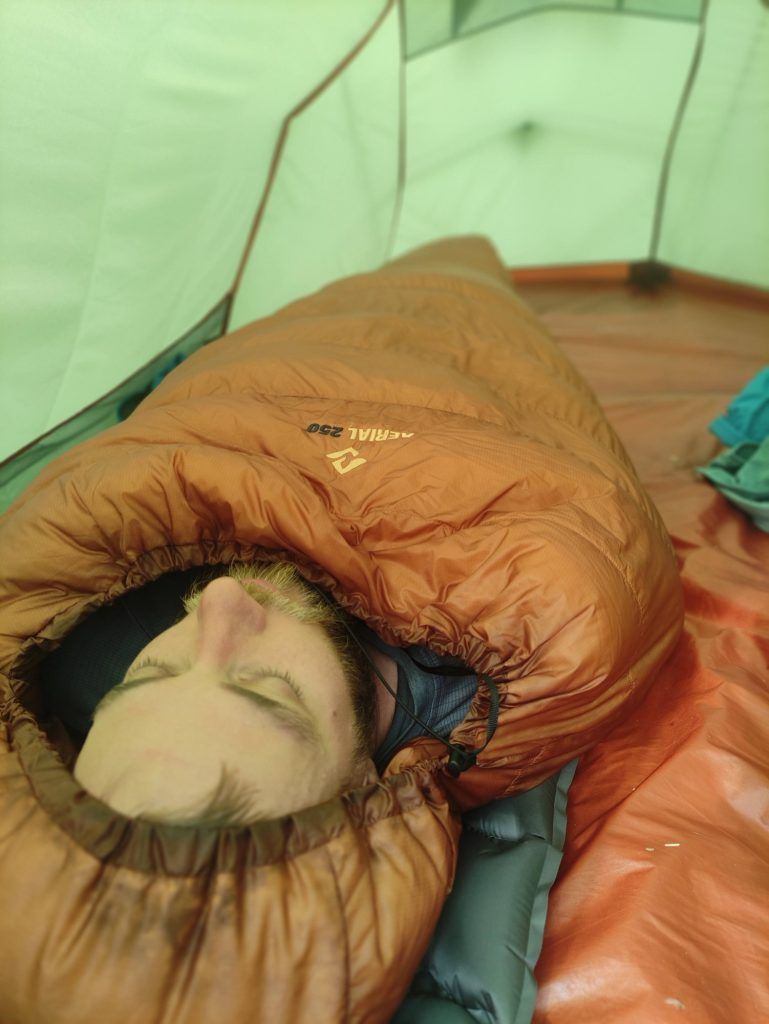 Tester im Cumulus Aerial 250 Schlafsack auf einer Isomatte in einem Zelt.